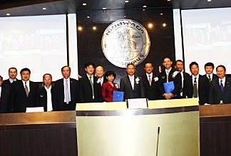 City and national officials pose for a commemorative photo after signing a memorandum of understanding for an automated traffic control system.